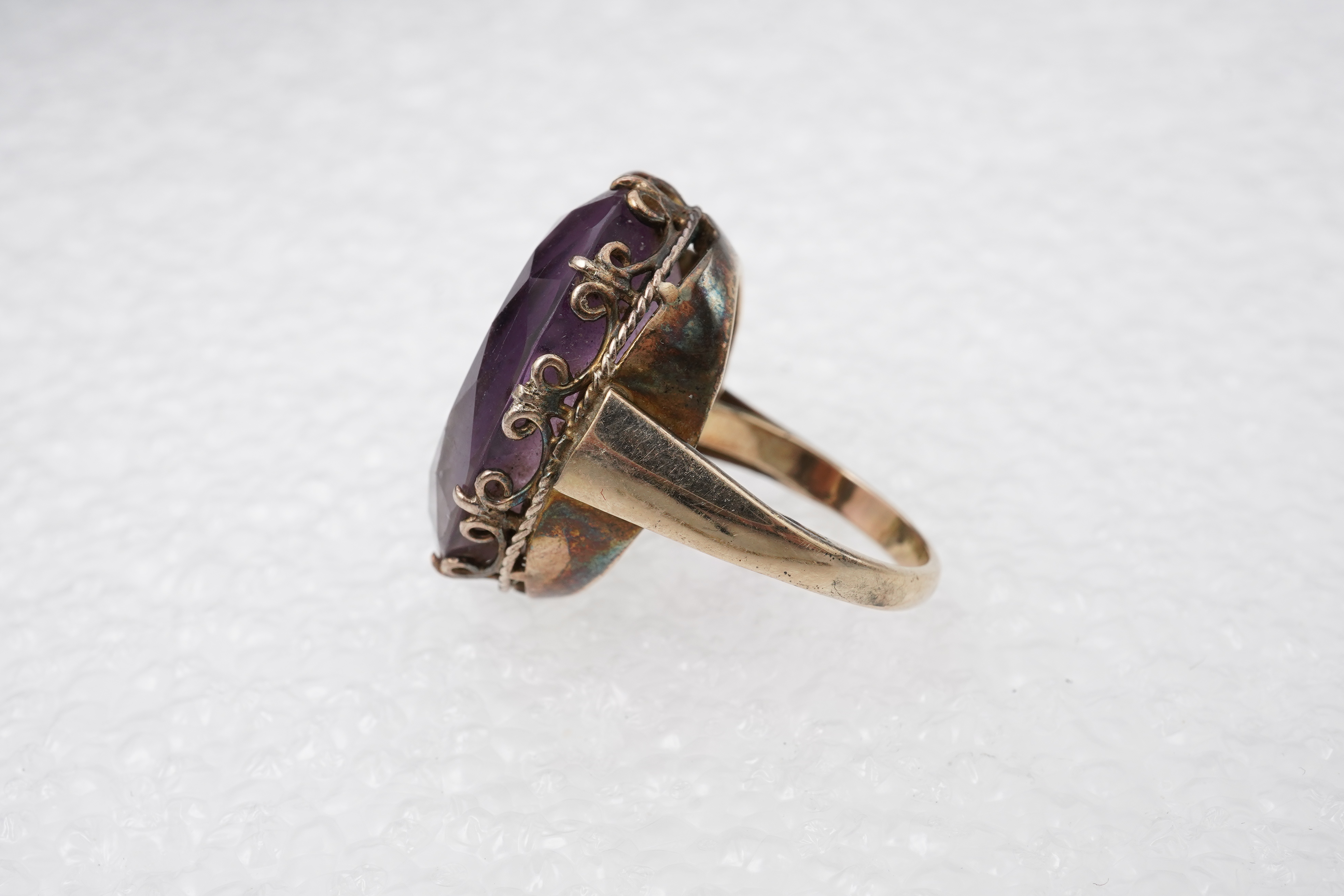 An amethyst ring, necklace and pendant, comprising: an oval amethyst set in a floral gilt silver necklace, length 32cm; an oval amethyst and seed pearl pendant, length 3.7cm; and a ring set with an oval amethyst, mounted